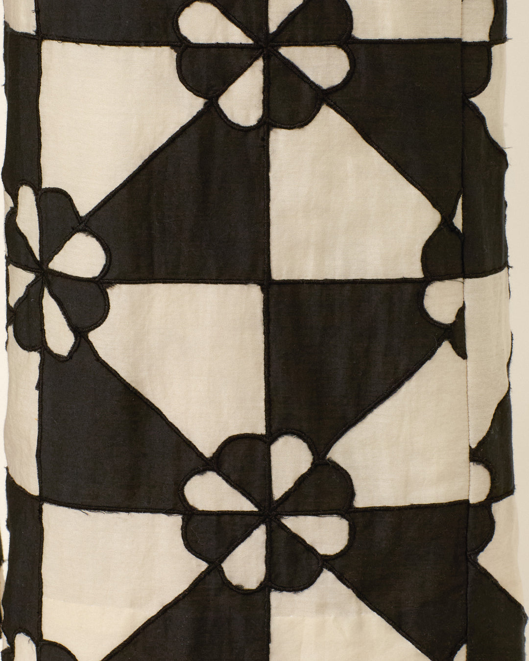 The Scout Onyx Jubilee Pant showcases black and white fabric with a mosaic-inspired pattern of interlocking squares and stylized flowers, evoking classic patchwork pant designs.