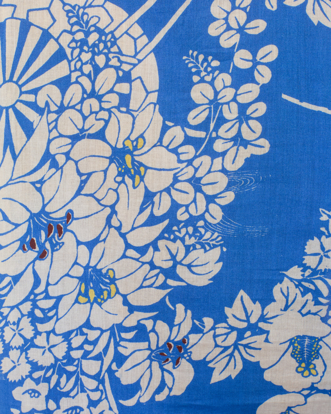 The Ophelia Royal Spoke Shirt is a blue and white cotton voile blouse with floral and geometric patterns, featuring large white flowers plus yellow, red, and blue accents—perfect for an elegant puff shoulder look.