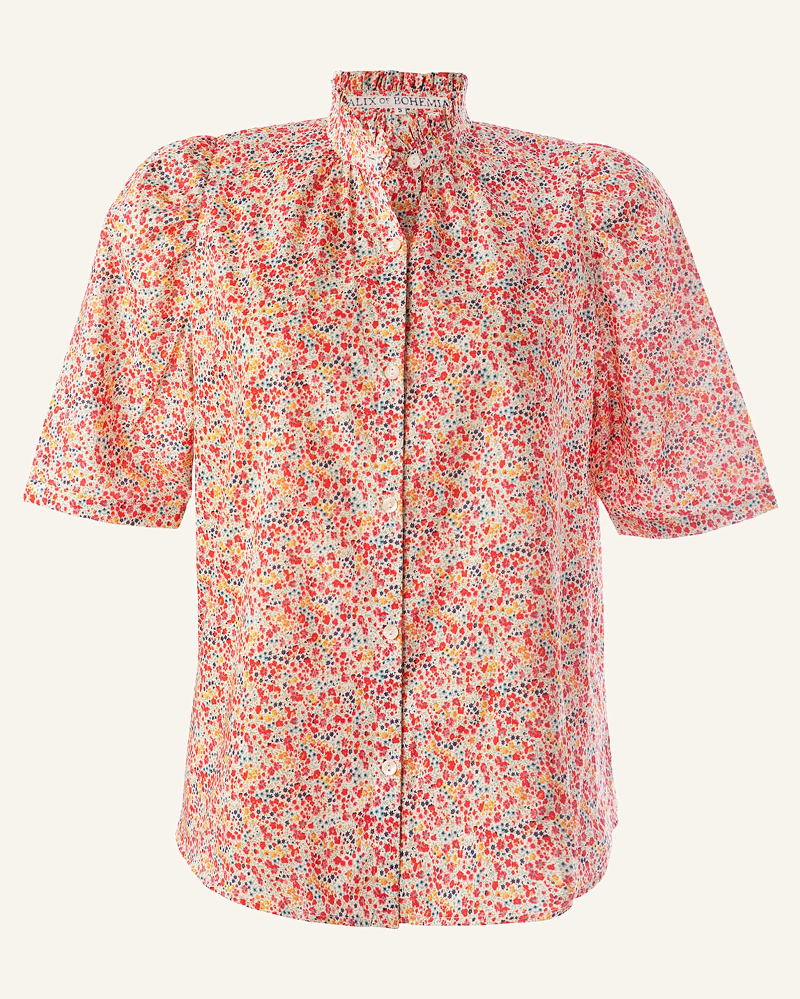 The Winnie Liberty Phoebe Shirt is a cotton blouse with short sleeves and a high ruffled collar, showcasing a floral print that blends red, pink, and white flowers on a light background. It features buttons down the front and offers a comfortable, loose fit, making it an essential addition to women's clothing collections.