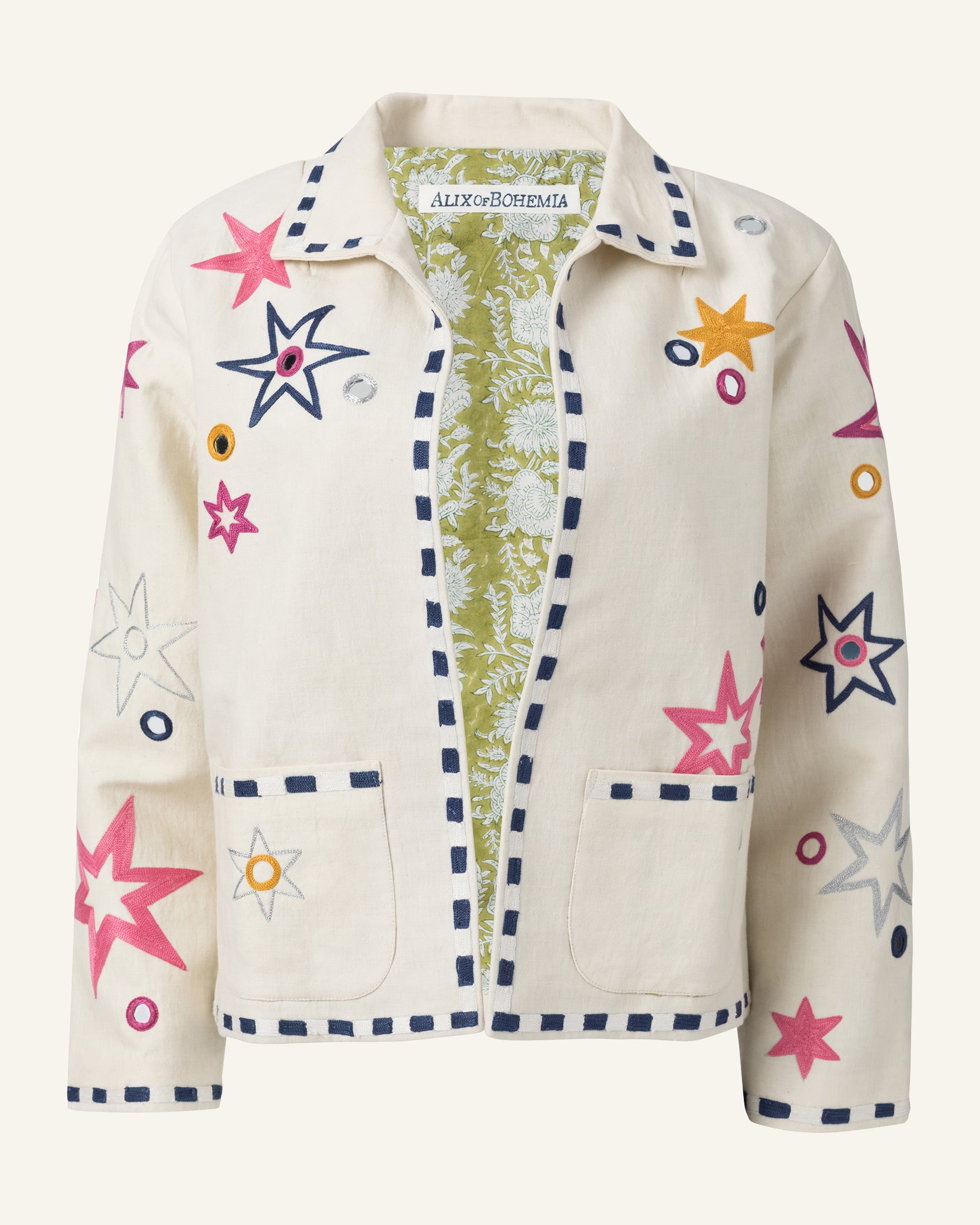 Introducing the Lucky Star Jacket: a cream-colored cotton linen piece adorned with vibrant star patterns in shades of pink, yellow, and orange. This jacket features hand embroidery along a decorative blue border that outlines the edges and patch pockets, complemented by a floral design lining inside.